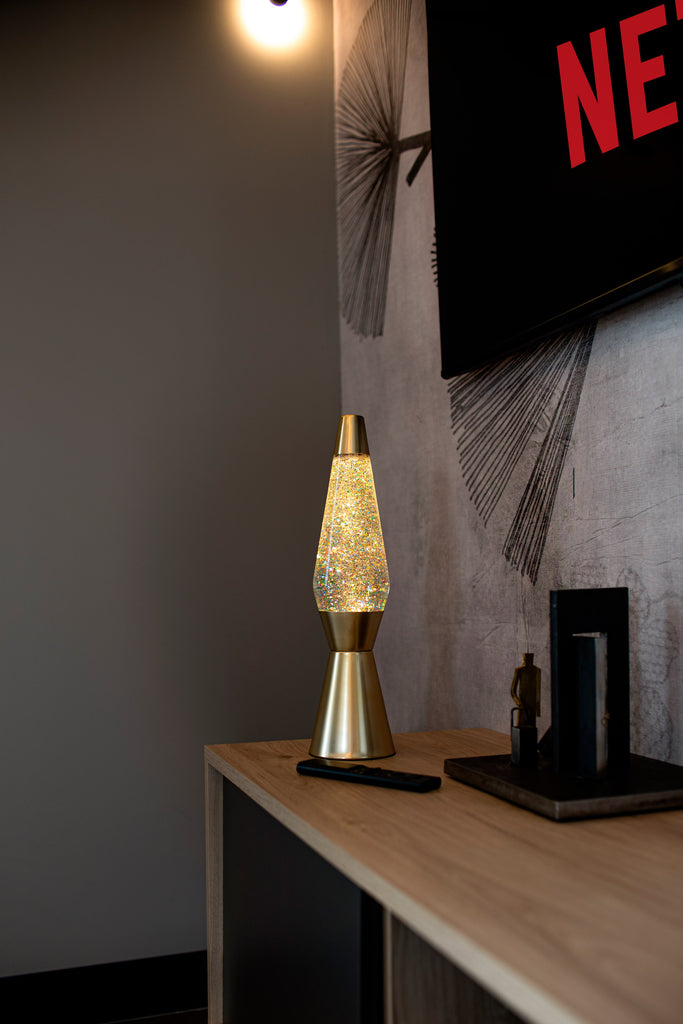 Lámpara de Lava 'Bullet' con base oro mate, líquido transparente y lava purpurina oro